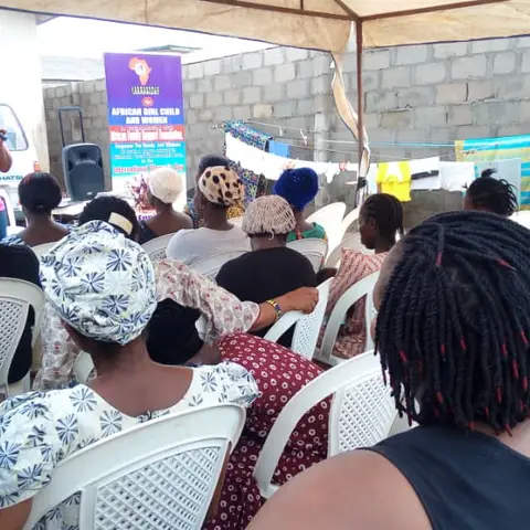 Foundation volunteers and community members pose with boxes of donated food supplies and toiletries during an Africa Mission outreach visit.