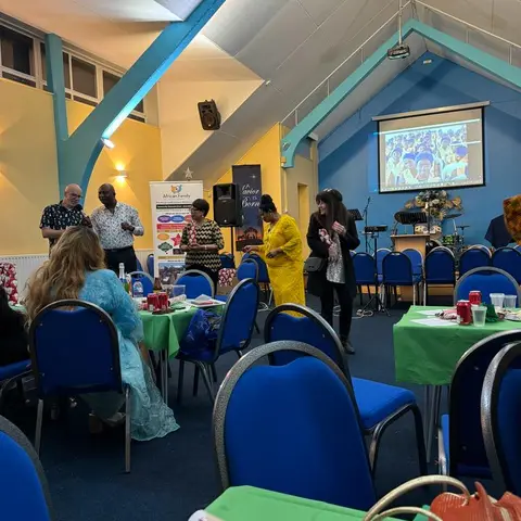 A man enthusiastically holding up two wrapped Christmas gifts in celebration.