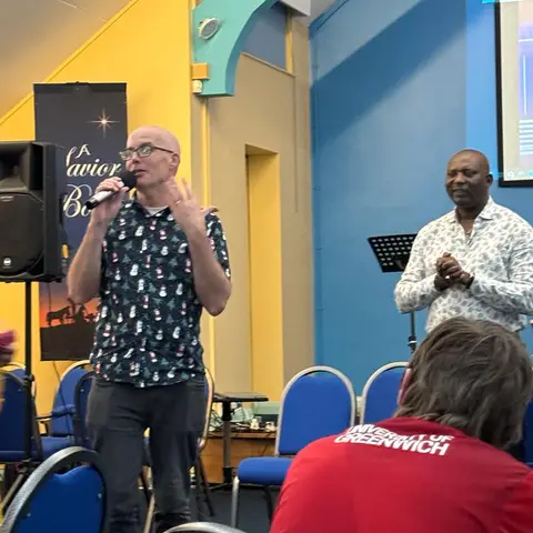 Three guests seated at a table with drinks and gifts, smiling for the camera.