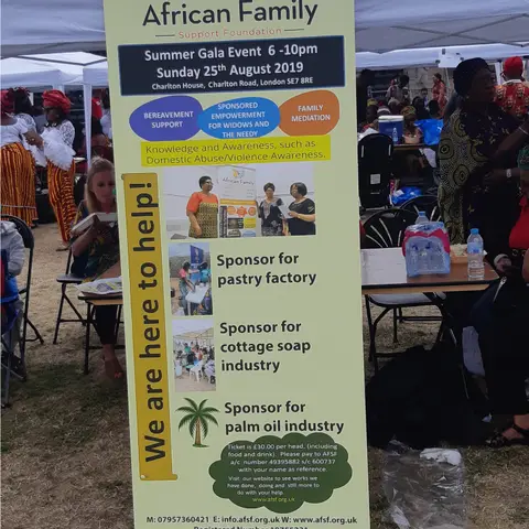 A tall promotional banner for the 'Summer Gala Event' by African Family Support Foundation standing on a grassy field at an outdoor event.