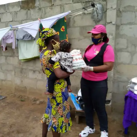 A group of women standing outdoors with a banner for African Girl Child and Women.