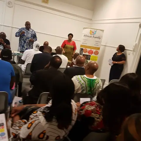 A group of people seated at a long head table during a formal banquet.