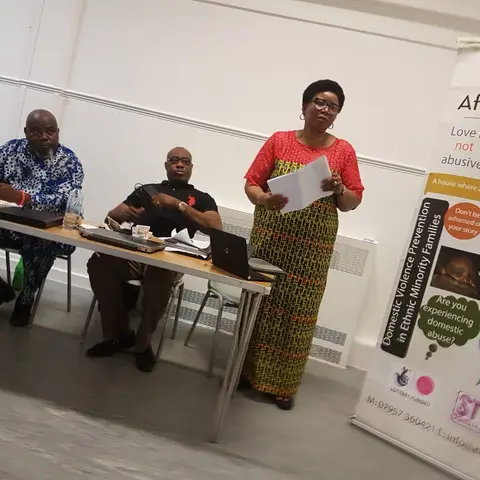 Women seated at a table in a formal hall during a gala event.