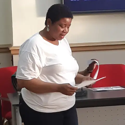 A view of a formal hall with many round tables and guests.