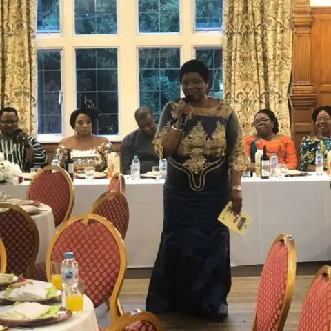 Participants seated in blue chairs during a community workshop or seminar.