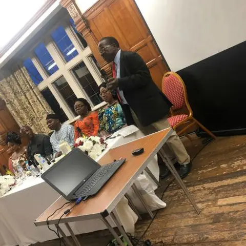 An audience of men and women listening attentively at a community event.