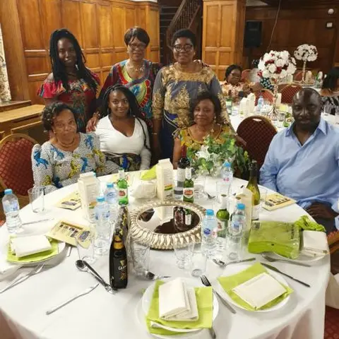 A group of people at a workshop standing around a tall informative poster.