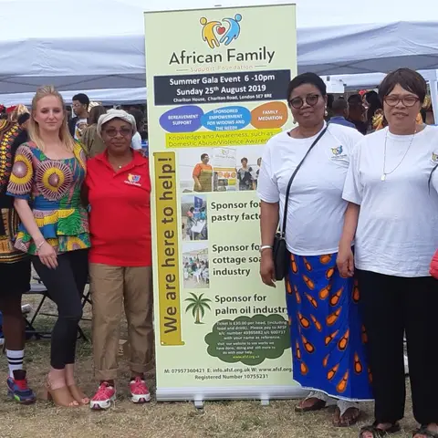 A group photo of community members and foundation staff with an AFSF banner.