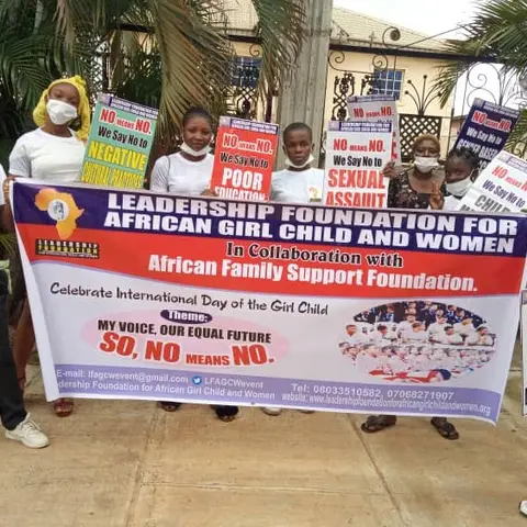 A stack of rice bags on a purple table next to an AFSF banner.